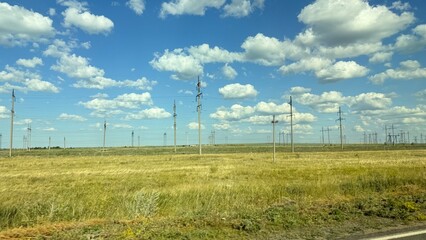 Many high-voltage transmission tower and electricity pylon power lines against blue sky with cloud