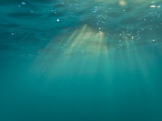 Fototapeta premium Ocean blue underwater with sunrays, Underwater Sea Deep Water Abstract Sunshine, sea wave , clean waters in summer time, Natural underwater seascape, sand on ocean floor and water surface with sunligh