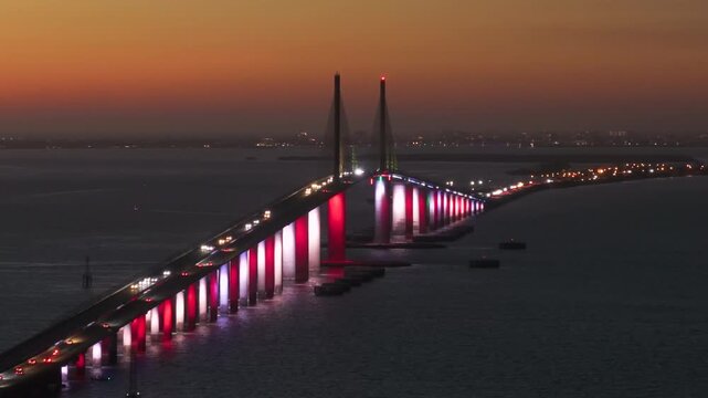 Highway road traffic driving at night over Sunshine Skyway Bridge in Florida. Transportation infrastructure in USA