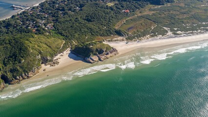Aerial view of Ilha do Mel coastline with lush vegetation and turquoise ocean in Paraná, Brazil.