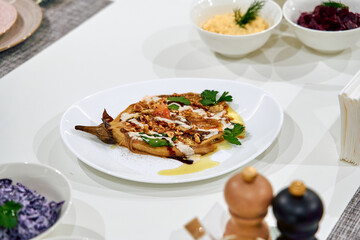 A beautifully arranged plate featuring a gourmet dish with a blend of textures and flavors, garnished with fresh herbs and vibrant colors on a stylish table setting.