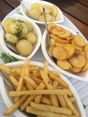 Teller mit Beilagen. Pommes, Bratkartoffeln und Klöße.