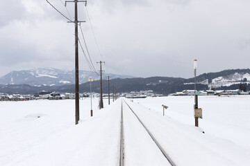 Railroad tracks stretching through a snowy landscape