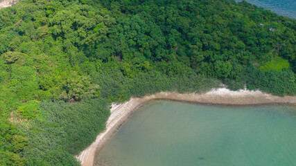 View of Forested Island Surrounded by Coastal City and Mountains