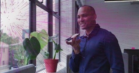 Businessman raising smartphone making business call at window with purple radial pattern growing - Powered by Adobe