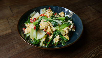 Stir-fried bok choy or pak choy with scrambled eggs, showcasing vibrant green and golden colors. Healthy cooking, Asian cuisine, food blogs, and recipe illustrations. Close up