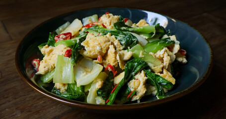 Stir-fried bok choy or pak choy with scrambled eggs, showcasing vibrant green and golden colors. Healthy cooking, Asian cuisine, food blogs, and recipe illustrations. Close up
