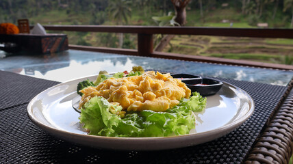Freshly cooked golden yellow scrambled eggs served hot on a plate with vegetables and condiments. Perfect for breakfast, culinary blogs, food styling, and recipe illustrations. Close up