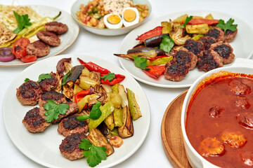 A Flavorful Spread of Grilled Meats, Roasted Vegetables, and Hearty Sauce Showcasing the Richness of Culinary Traditions on a Dining Table