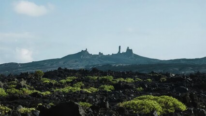 Volcanic Landscape with Lush Greenery and Distant Rock Formations
