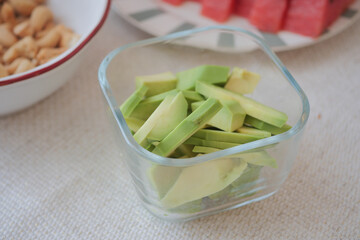 Freshly cut green vegetables in a glass container on a table