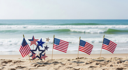 American flags and patriotic star decorations planted in sand on a sunny beach with ocean waves