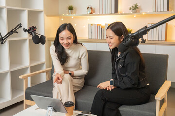 Podcasting. Two women enjoying a fun moment while recording a podcast.