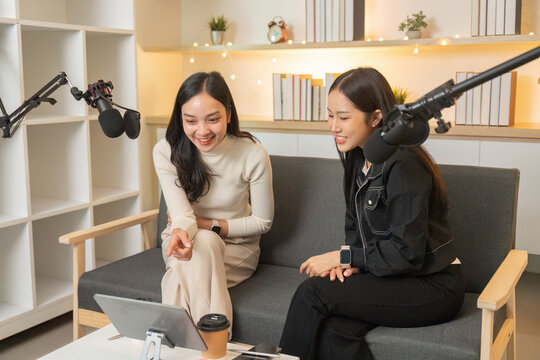 Podcasting. Two women enjoying a fun moment while recording a podcast. - Powered by Adobe