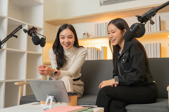 Podcasting. Two women sharing laughter and ideas during a recording session. - Powered by Adobe