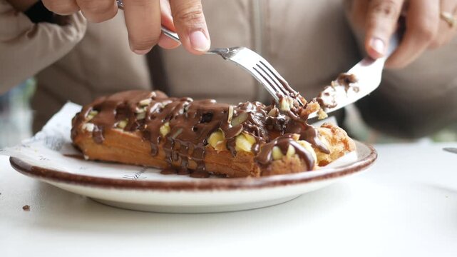 Enjoying a chocolate eclair in a cozy cafe setting