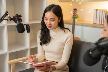 Podcast Preparation. Woman taking notes during a creative discussion in a studio.