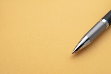 Metal pen, black grip, and silver tip lying perfectly straight on blank beige background, minimalistic and professional office supply concept, evoking calm and focus