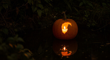 Eerily Illuminated Carved Pumpkin with Candlelight Reflected in Dark Water