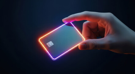 Hand holding a glowing credit card with neon light