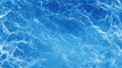 Obraz premium Gentle waves ripple across an expansive ocean surface, shimmering in bright sunlight. The deep blue hues create a tranquil and calming atmosphere at midday along the coastline.