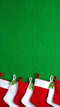 Festive Christmas Stockings Hanging on a Vibrant Green Wall Ready for Holiday Cheer and Gifts with Family and Friends