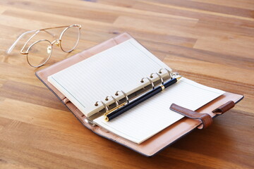 Opened Organizer with Pen on Table
