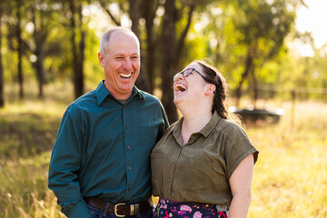 portrait of smiling middle aged man and adult daughter in her twenties