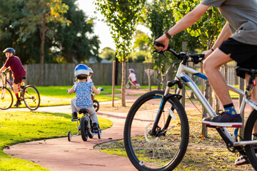 children riding bicycles on bike track at park together