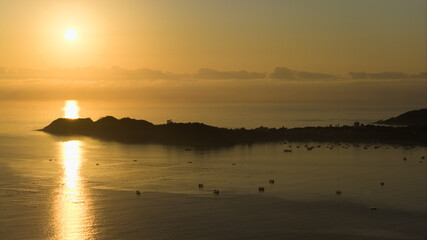 Sunset over the Atlantic Ocean in Brazil with fishing boats scattered across calm waters.