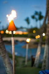 Lit Hawaiian Tiki Torch with a Warm Glow on a Tropical Beach