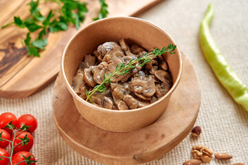 Delicious Mushroom Dish Served in a Rustic Bowl Surrounded by Fresh Ingredients Like Herbs and Cherry Tomatoes on a Natural Wooden Surface