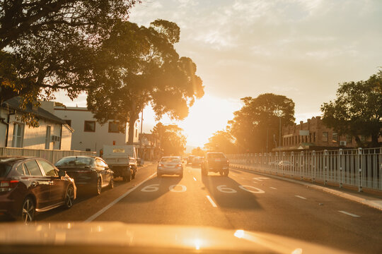 Traffic along urban street in vibrant afternoon sunlight