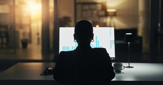 Business person, computer screen and night at office with finance graphs, back and silhouette at company. Corporate investor, broker and reading with trading statistics, charts and feedback at agency - Powered by Adobe