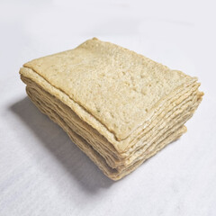  A series of images demonstrating the process of preparing square fish cake pieces. The first few images show a person's hand picking up and folding the thin slices of fish cake. Subsequent images sho