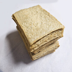  A series of images demonstrating the process of preparing square fish cake pieces. The first few images show a person's hand picking up and folding the thin slices of fish cake. Subsequent images sho