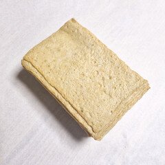  A series of images demonstrating the process of preparing square fish cake pieces. The first few images show a person's hand picking up and folding the thin slices of fish cake. Subsequent images sho