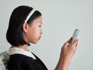 夏休みの子供が家のリビングでスマホを見ている様子