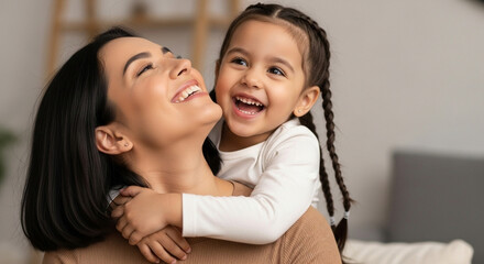 A joyful young daughter giving her mother a loving hug from behind in a sunlit room, perfect for illustrating a strong mother-daughter bond and happiness