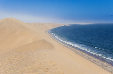 Sand dunes on ocean shore of Sandwich harbour, Atlantic coast of Namibia, South Africa