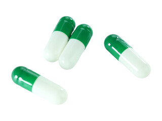 Bulk green and white capsule pills isolated on white background.
