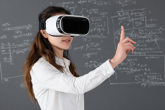 Asian teacher wearing virtual reality headset pointing on virtual blackboard teaching online using innovative technology in classroom