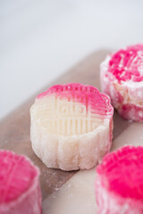 Homemade Chinese snow skin mooncakes. Snowy Moon cakes on a White Background. Mid-Autumn Festival, traditional Asian desserts, and seasonal celebrations in Asian countries