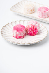 Homemade Chinese snow skin mooncakes. Snowy Moon cakes on a White Background. Mid-Autumn Festival, traditional Asian desserts, and seasonal celebrations in Asian countries