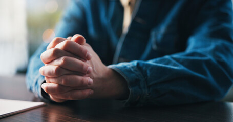 Job application, hands and prayer with person at desk in apartment for hope, opportunity or request. Documents, guidance and wish with man praying at table in home for career development or growth