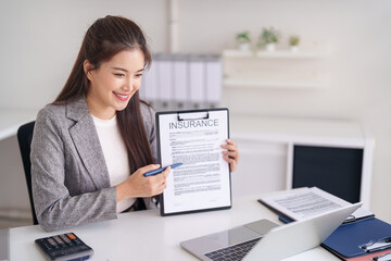 Asian adult professional insurance agent explains policy document benefits to client ensuring home protection and financial future