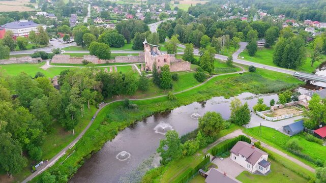 Aerial View of Dobele Castle Ruins, Flowing Berze River and Illuminated Fountains at Sunset Serene Latvian Summer Evening from Above, Scenic Aerial of Latvian Historical Landscape in Golden Hour