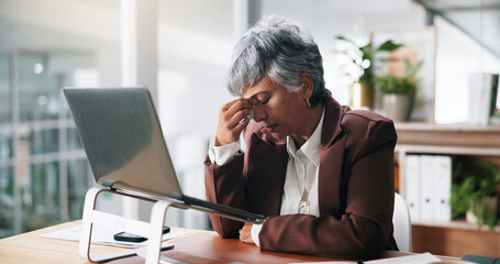 Obraz premium Business, headache and woman in office, pain and laptop with stock market crash, stress or tension. Mature person, accounting or employee with PC, crypto error or migraine with fatigue and exhausted