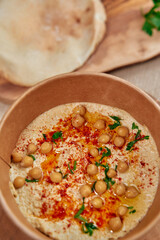 Delicious Chickpea Dip with Olive Oil and Spices, Served with Fresh Bread on Rustic Wooden Table for a Flavorful Culinary Experience