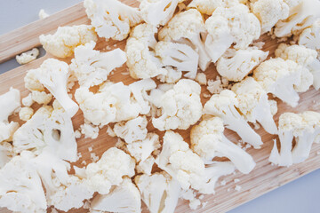 chopped cauliflower on wooden cutting board for healthy cooking themes